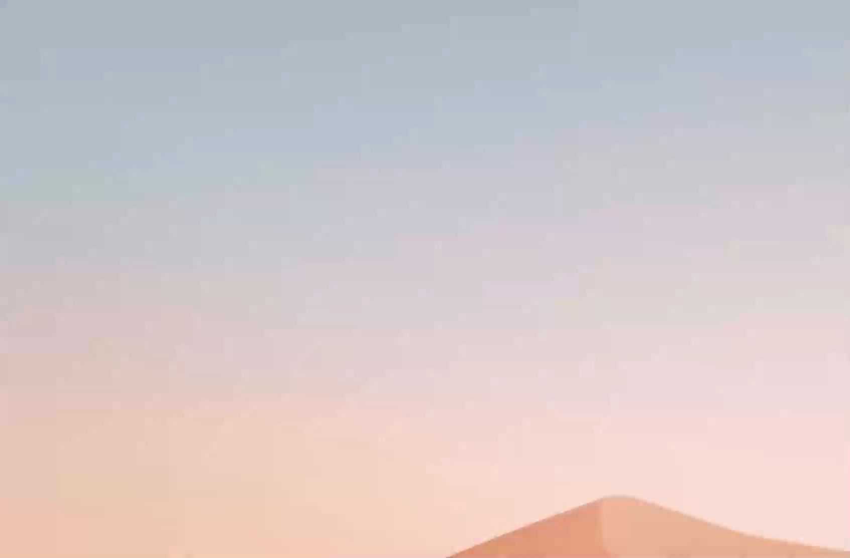 Soft pastel gradient fading from grey-blue to peach